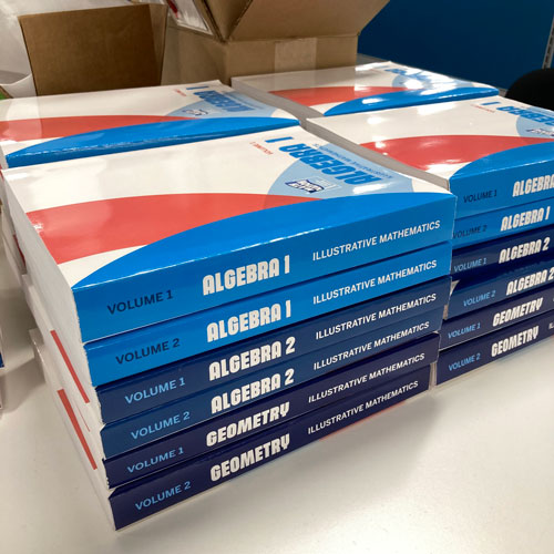 Photograph of twenty four math workbooks produced by Jimmy Hines
